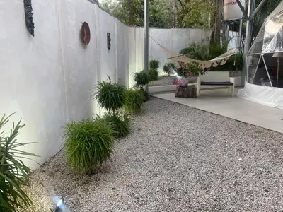 a patio with potted plants and a hammock at Amaj Eco Lodge in Sámara