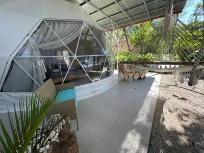 a hammock in a tent in a garden at Amaj Eco Lodge in Sámara
