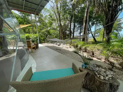 a patio with a table and chairs and trees at Amaj Eco Lodge in Sámara
