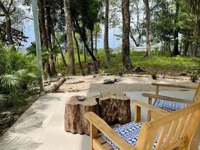 a patio with a bench and a table and trees at Amaj Eco Lodge in Sámara