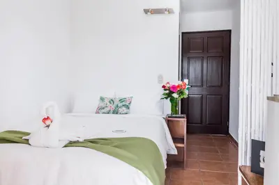 a bedroom with a bed with white sheets and a door at The Palms At Coco Beach in Coco