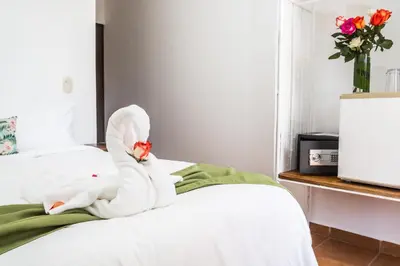 a white swan doll sitting on a bed at The Palms At Coco Beach in Coco