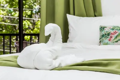a white towel animal sitting on a bed at The Palms At Coco Beach in Coco