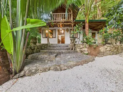 a house with a bunch of stairs in front of it at Pachamama Bungalows & Surfcamp - Santa Teresa in Carmen