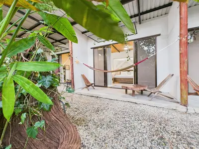 a patio of a house with two chairs and a bench at Pachamama Bungalows & Surfcamp - Santa Teresa in Carmen
