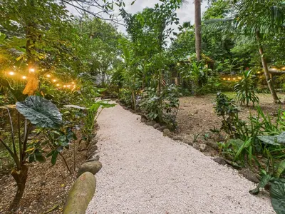 a path in a garden with lights on it at Pachamama Bungalows & Surfcamp - Santa Teresa in Carmen