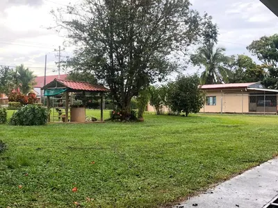 a yard with a house and a tree and a building at Hospedaje Adrimaran in Palmares
