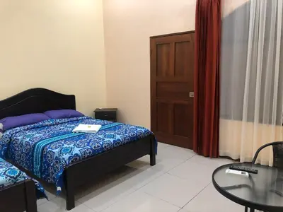 a bedroom with a bed and a table and a door at Hospedaje Adrimaran in Palmares