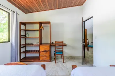 a bedroom with a desk and a chair in a room at Tropical House in Nosara- 3 min walk to the beach in Río Seco