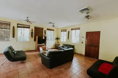 a living room with two couches and a tv at La Posada Jungle Hotel in Manuel Antonio