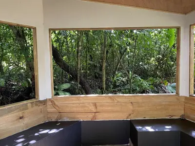 a window in a room with benches in front at La Posada Jungle Hotel in Manuel Antonio