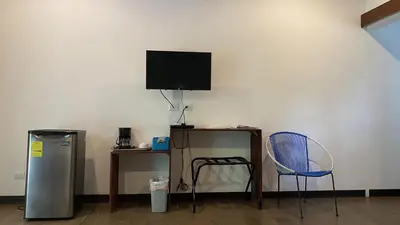 a room with a television and a table and a chair at La Posada Jungle Hotel in Manuel Antonio