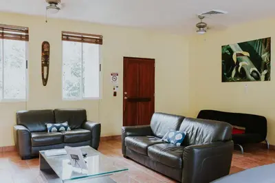 a living room with two leather couches and a table at La Posada Jungle Hotel in Manuel Antonio