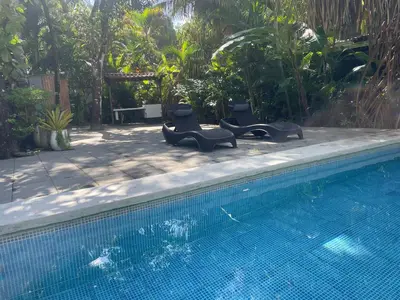 a swimming pool with two lounge chairs next to it at Beach Villa S in Santa Teresa Beach