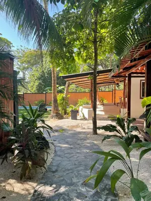 a patio with trees and a pavilion in a yard at Beach Villa S in Santa Teresa Beach