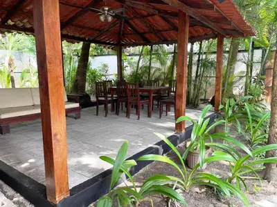 a wooden pavilion with a table and chairs at Beach Villa S in Santa Teresa Beach