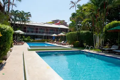 a swimming pool in front of a hotel at Hotel Mar de Luz in Jacó