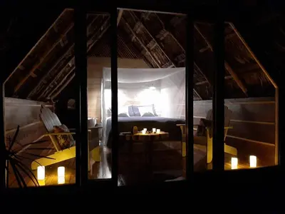 a room with a bed and a table with candles at Poponé Farm & Lodge in Guápiles