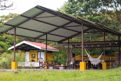 awning over a patio of a house with a hammock at Poponé Farm & Lodge in Guápiles