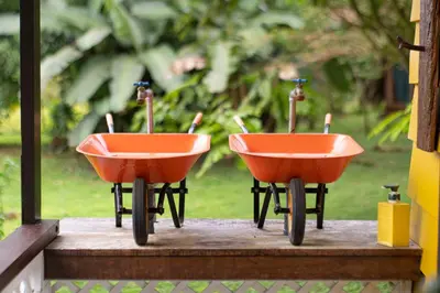 two orange wheelbarrows sitting on a window sill at Poponé Farm & Lodge in Guápiles