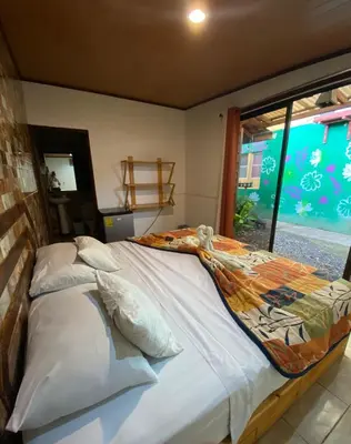 a large bed in a room with a window at Hotel Sunset Rooms in Tortuguero
