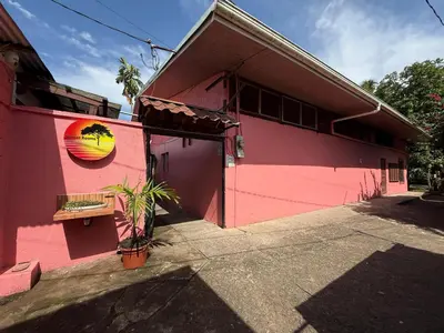 a pink building with a sunset painted on it at Hotel Sunset Rooms in Tortuguero