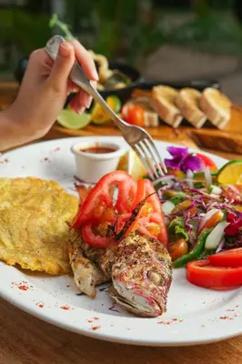 a plate of food with meat and vegetables on a table at Hotel Playa Espadilla & Gardens in Manuel Antonio