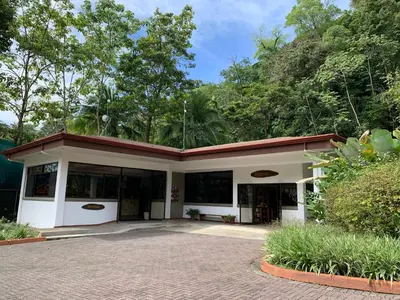 a white building with a red roof at Hotel Playa Espadilla & Gardens in Manuel Antonio