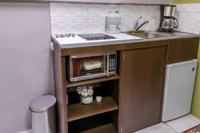 a kitchen counter with a microwave and a sink at Delcafetalcr in San José