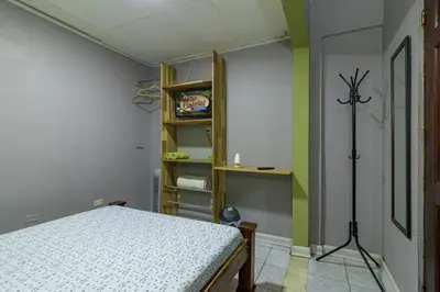 a bedroom with a bed and a green wall at Delcafetalcr in San José