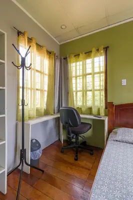 a bedroom with a bed and a desk and a chair at Delcafetalcr in San José