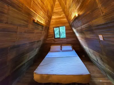 a room with two beds in a wooden cabin at Buena Onda Bungalows in Santa Teresa Beach