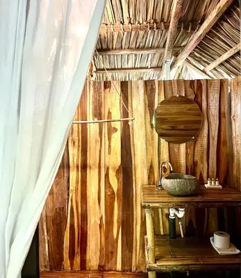 a room with a wooden wall with a table and a mirror at Buena Onda Bungalows in Santa Teresa Beach