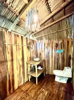 a bathroom with a toilet and a sink at Buena Onda Bungalows in Santa Teresa Beach
