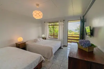a bedroom with two beds and a window at Ladera Hotel in Turrialba