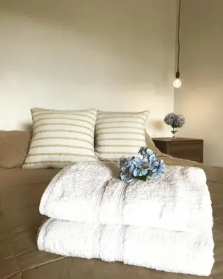 a white blanket sitting on top of a bed at Ladera Hotel in Turrialba