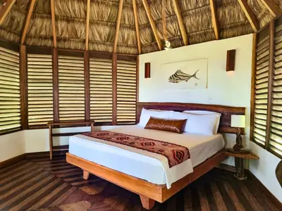 a bedroom with a bed in a room with windows at The Jaguars Jungle Rainforest Lodge - All meals included in San Pedrillo