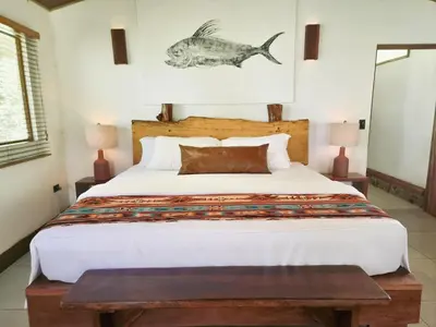 a bedroom with a bed with a fish on the wall at The Jaguars Jungle Rainforest Lodge - All meals included in San Pedrillo