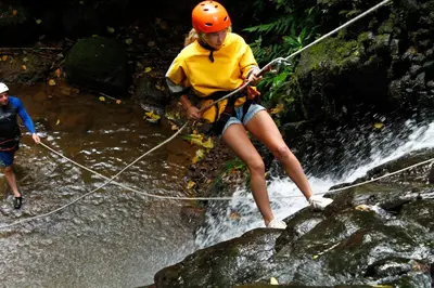 a woman on a rope bridge over a waterfall at Spanish by the River - Turrialba in Turrialba