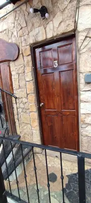 a wooden door on a stone building with a staircase at Apartotel VILLA ALTA TAMARINDO in Tamarindo