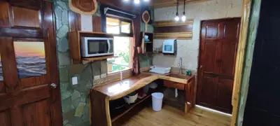 a small kitchen with a desk and a microwave at Apartotel VILLA ALTA TAMARINDO in Tamarindo