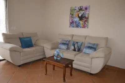 a living room with two couches and a table at Apartotel VILLA ALTA TAMARINDO in Tamarindo