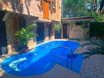 a swimming pool in the middle of a house at Apartotel VILLA ALTA TAMARINDO in Tamarindo