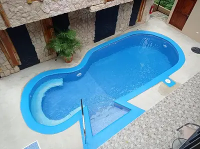 a swimming pool in a villa with a blue swimming pool at Apartotel VILLA ALTA TAMARINDO in Tamarindo