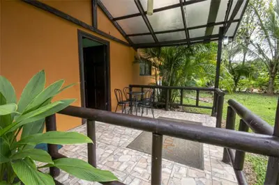a porch of a house with a table and chairs at Cabañas Río Escondido en La Fortuna in Fortuna