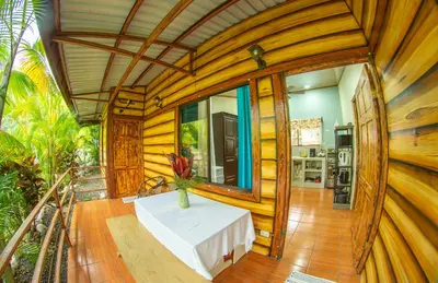 a wooden house with a table in a room at Cabañas Río Escondido en La Fortuna in Fortuna