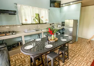 a kitchen with a table with four chairs and a refrigerator at Cabañas Río Escondido en La Fortuna in Fortuna