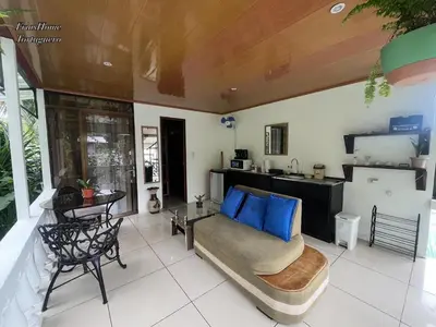 a living room with a bed and a kitchen at Frías Home in Tortuguero