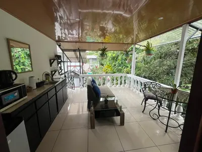 a kitchen and living room with a balcony at Frías Home in Tortuguero
