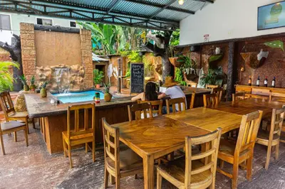 a group of people sitting at tables in a restaurant at Arenal Poshpacker Boutique Urban Tropical Hotel in Fortuna